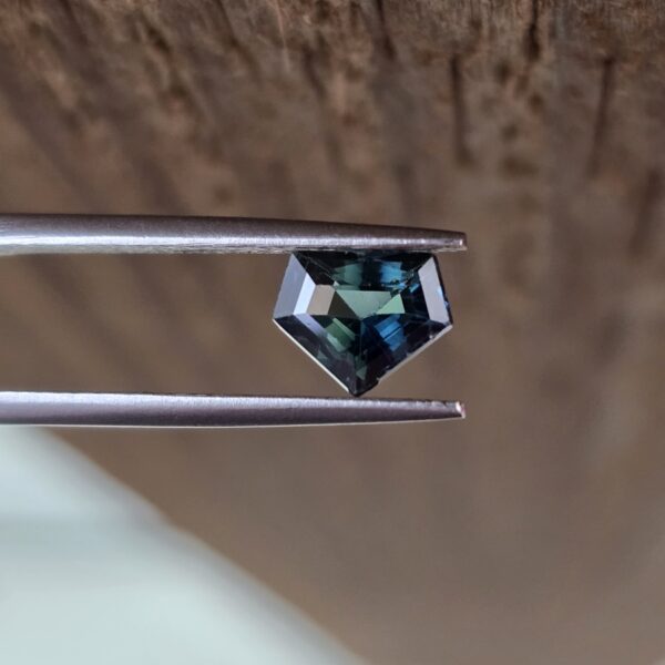 7.29x5.87x3.86mm 'superman' shield-cut, bi-colour/teal sapphire facet.