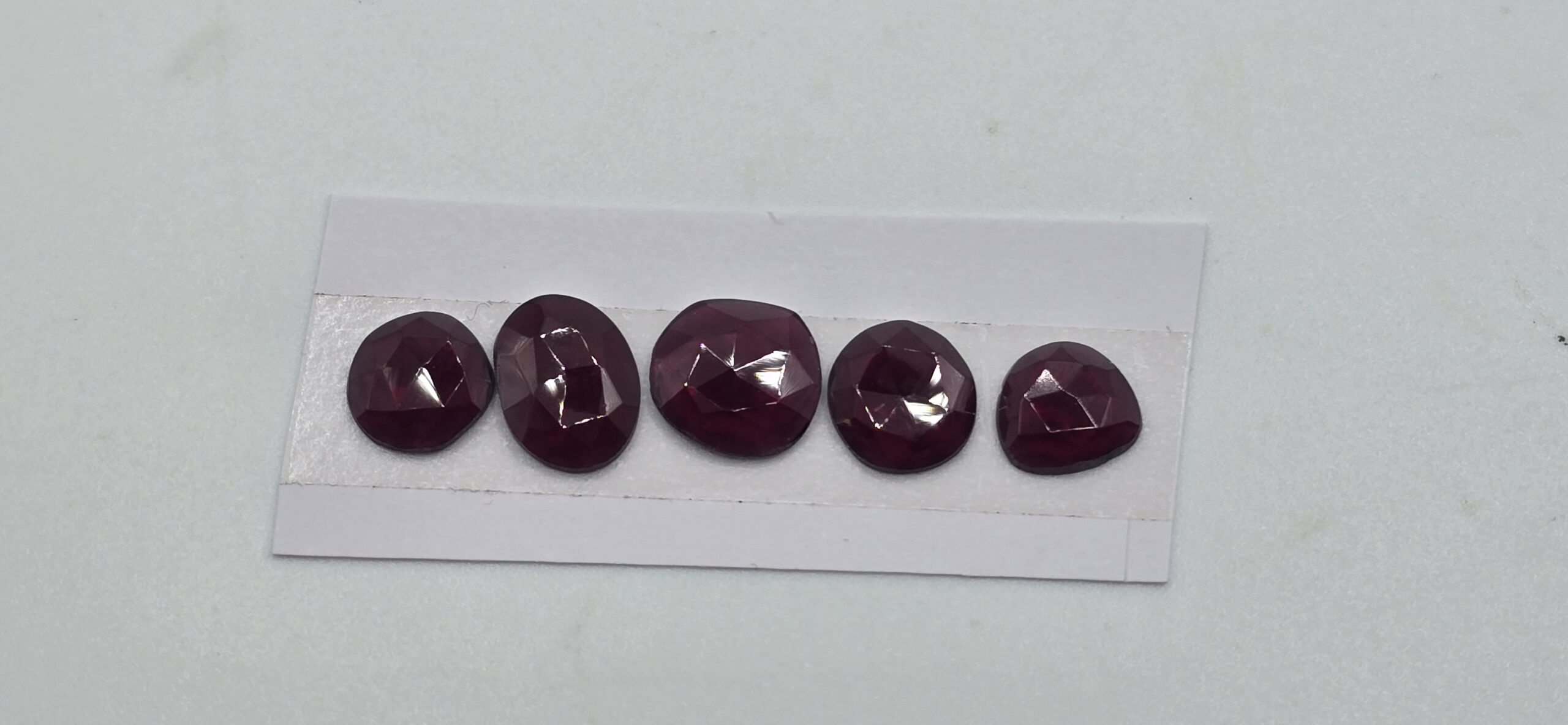 FIVE rose-cut red garnet cabochons