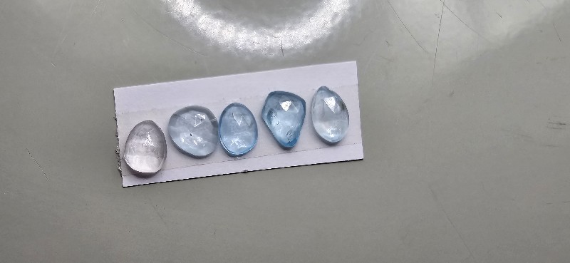 FIVE rose-cut sky blue topaz cabochons