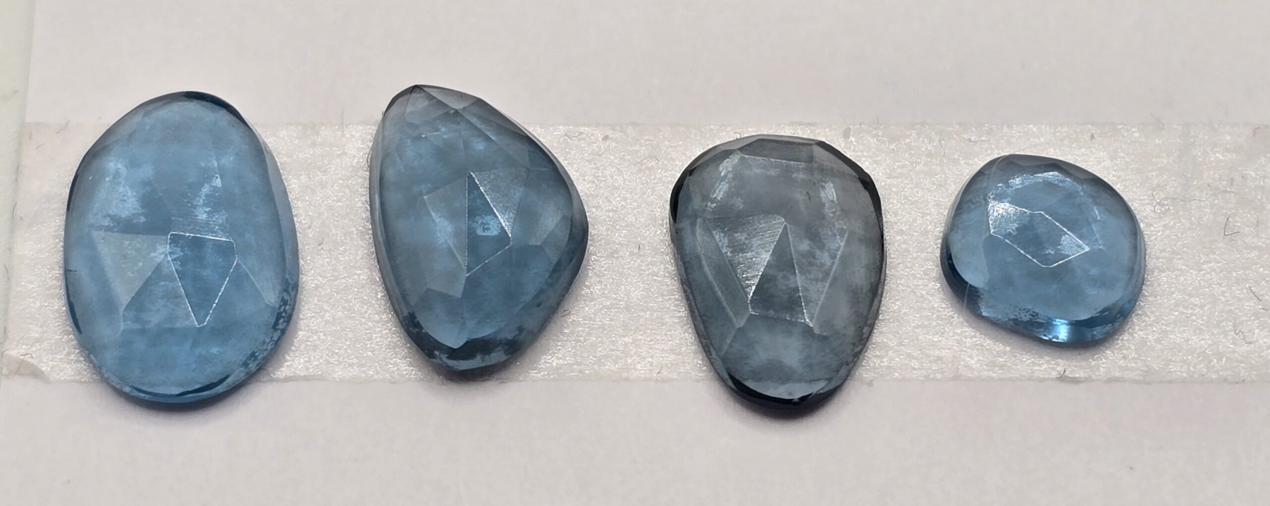 FOUR rose-cut London blue topaz cabochons