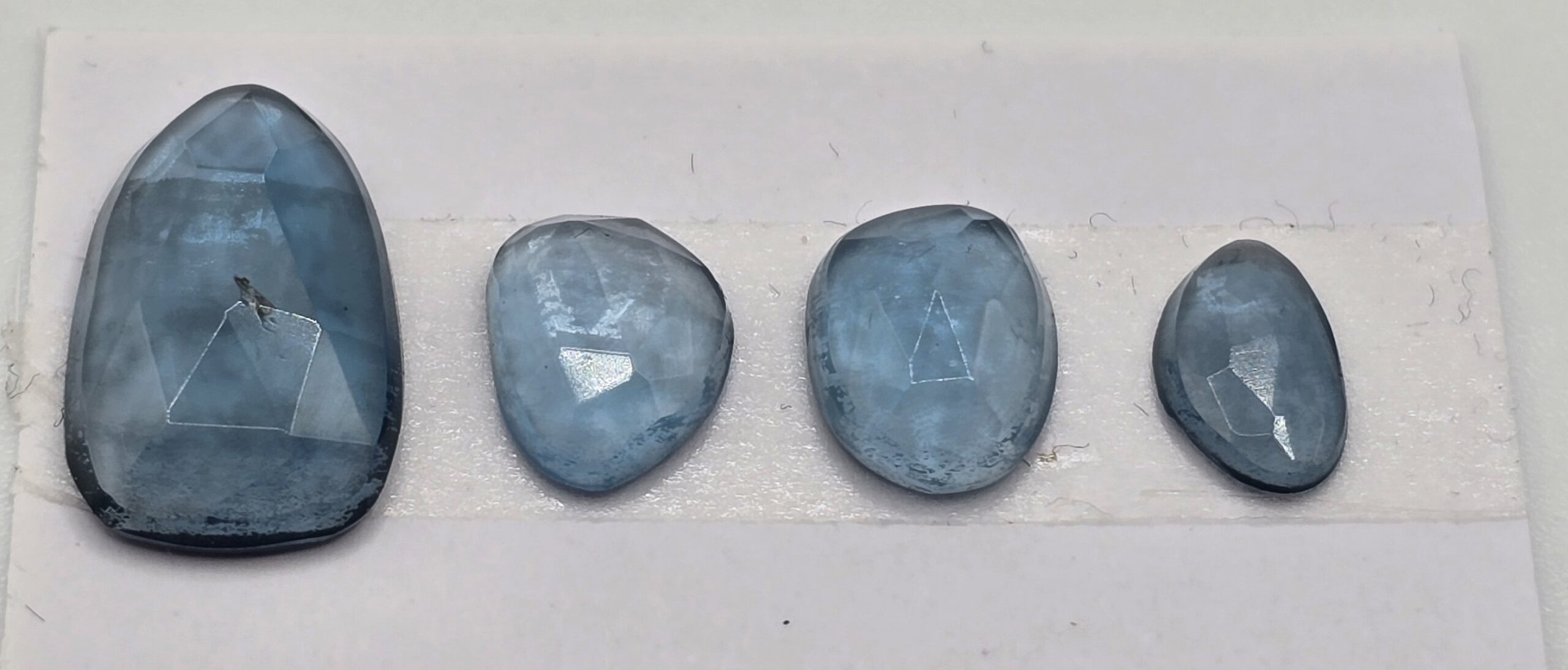 FOUR rose-cut London blue topaz cabochons