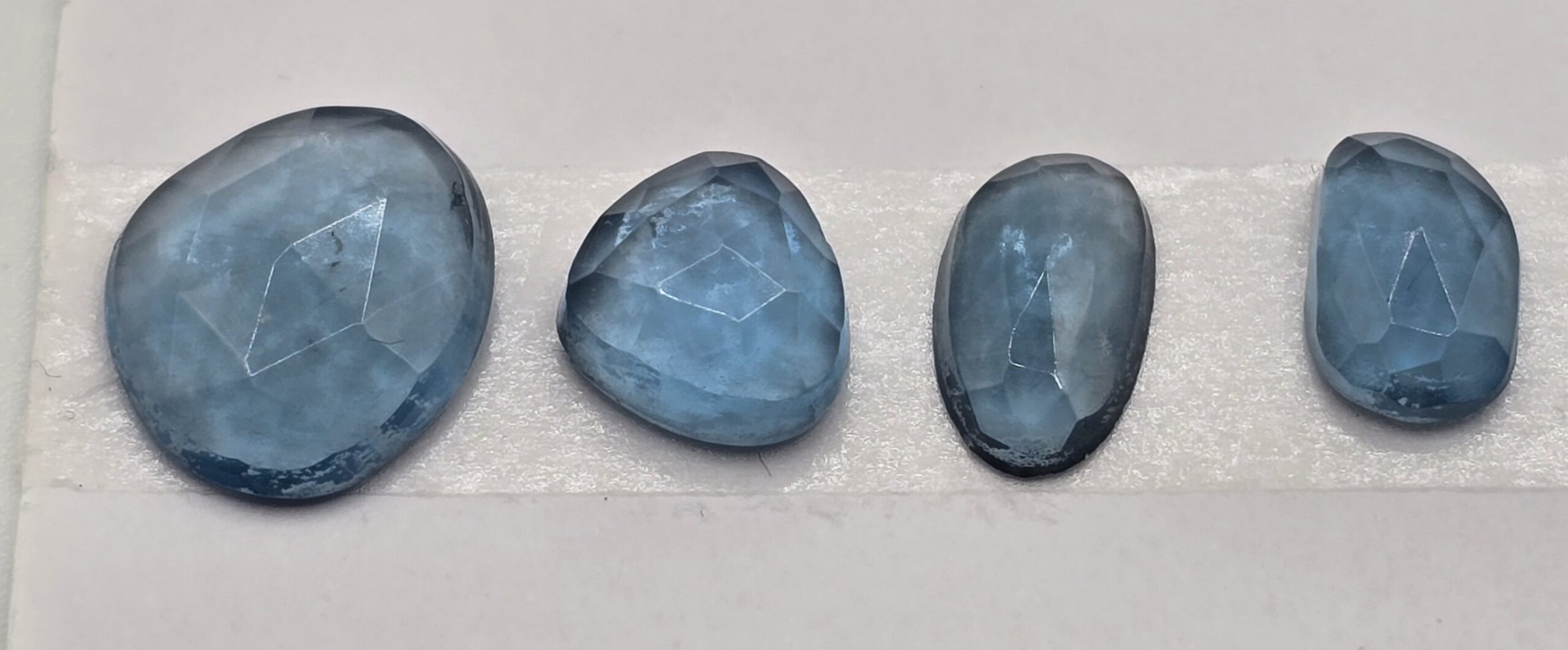 FOUR rose-cut London blue topaz cabochons