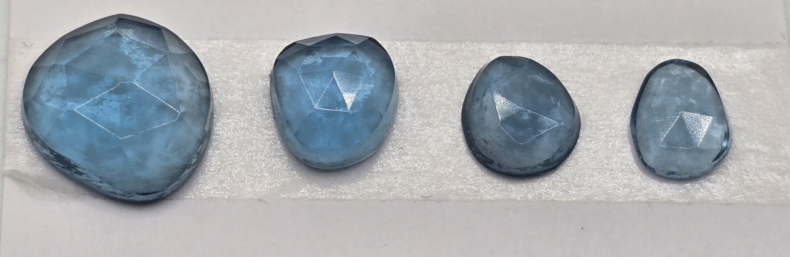 FOUR rose-cut London blue topaz cabochons