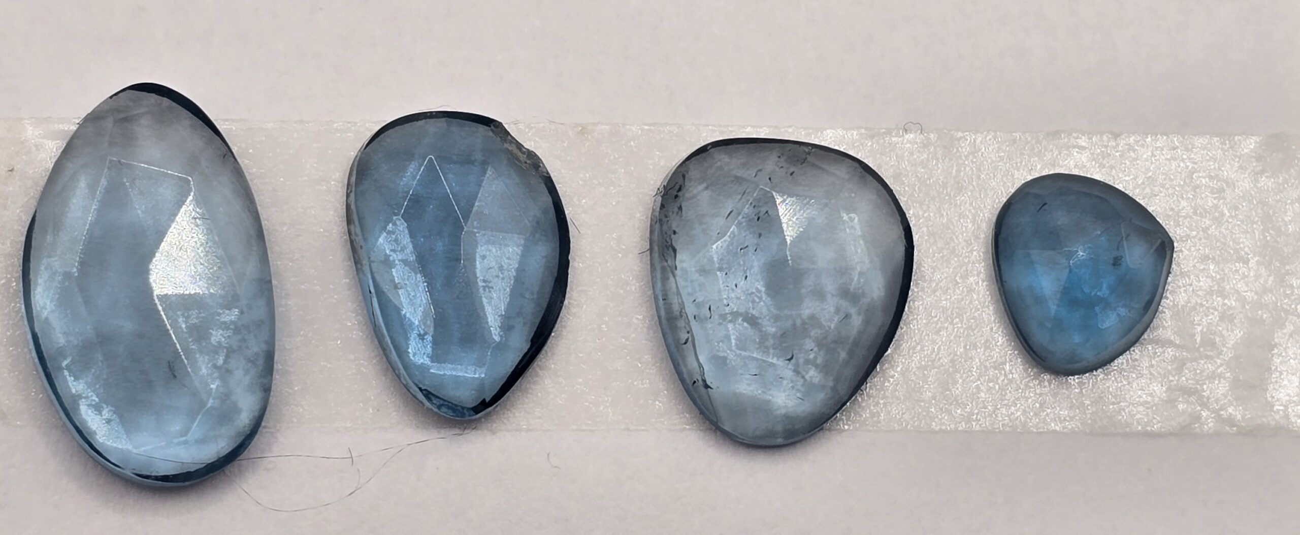 FOUR rose-cut London blue topaz cabochons